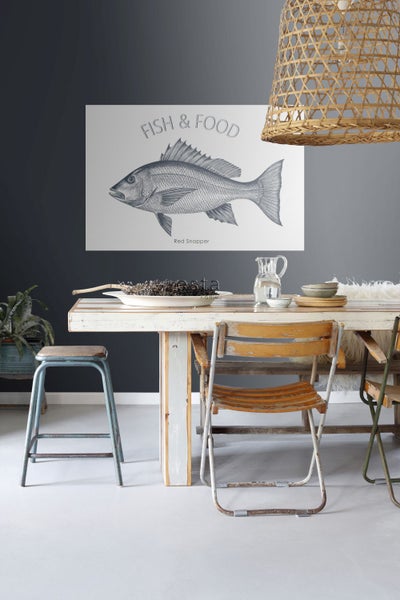Dekoratives Wandbild mit Fischmotiv über einem Esstisch mit Stühlen und Dekorationen