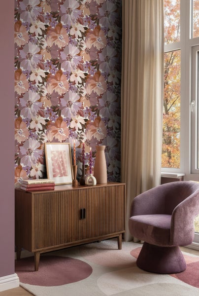 Wohnzimmer mit Blumentapete, Holzkommode, Dekoration und Sessel