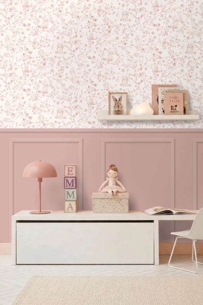 Kinderzimmer mit Tapete mit Hasenmuster und Wandpaneelen mit Tisch, Stuhl, Lampe und Dekoration im mädchenhaften Stil.