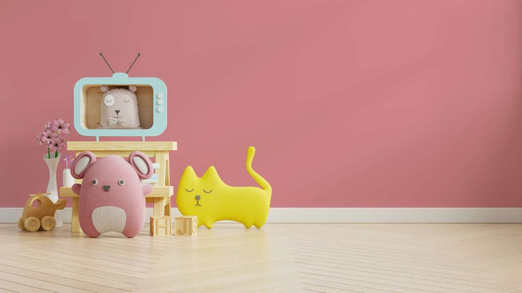 Kinderzimmer mit rosa Wand, hellem Holzfußboden in Fischgrätoptik und Spielzeugen wie Plüschtieren und Holzbausteinen.