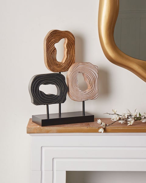 Dekorative Holzskulptur mit drei abstrakten Formen auf einem Kaminsims