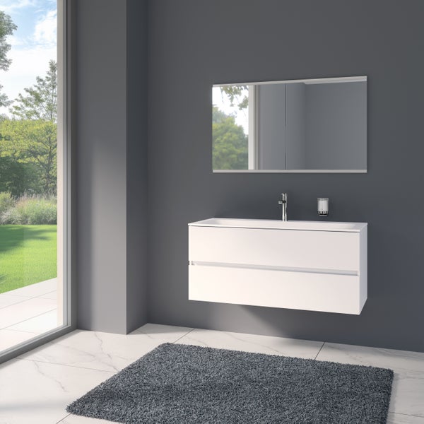 Modernes Badezimmer mit weißem Waschtischunterschrank, Waschbecken, Armatur, Spiegel und dunklem Teppich auf Marmorboden.