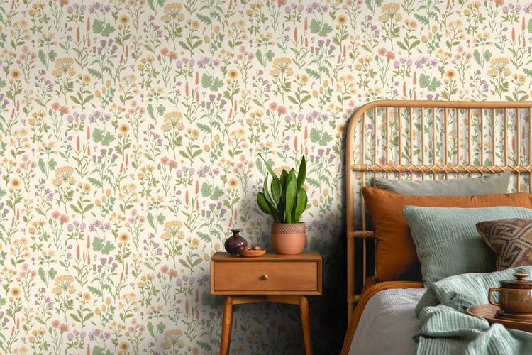 Schlafzimmer mit gemusterter Tapete, Rattansessel, Holztisch und Zimmerpflanze