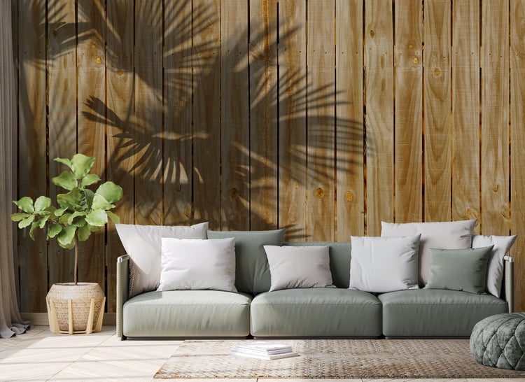 Vliesfototapete in Holzoptik mit vertikalen Holzlatten hinter einem Sofa und einer Zimmerpflanze im modernen Wohnzimmer.