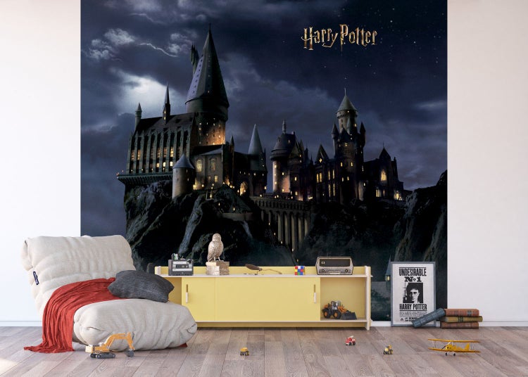 Wohnzimmer mit Harry Potter Schloss Hogwarts Tapete, Sessel und gelbem Schrank.