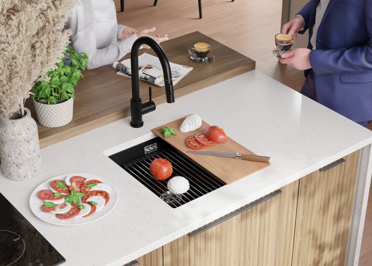 Küchenszene mit Spüle, Armatur, Schneidebrett, Geschirr und Lebensmitteln auf einer Küchentheke.