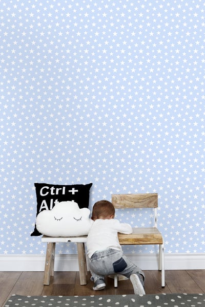 Kinderzimmer mit Sternentapete, Stuhl und Dekokissen