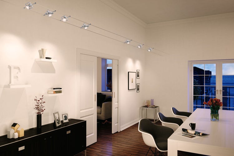 Helles Wohnzimmer mit Seilsystemleuchte über dem Esstisch