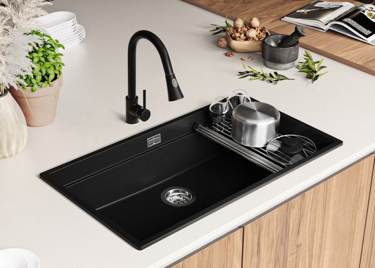 Schwarze Küchenspüle mit schwarzem Wasserhahn auf einer Küchentheke
