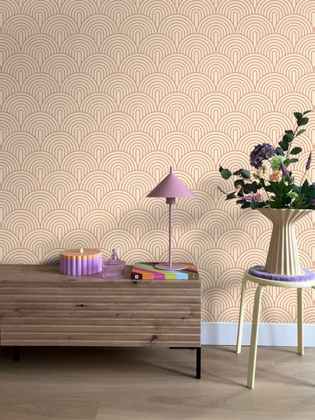 Innenraum mit gemusterten Tapeten, Sideboard, Tischlampe und Blumenarrangement