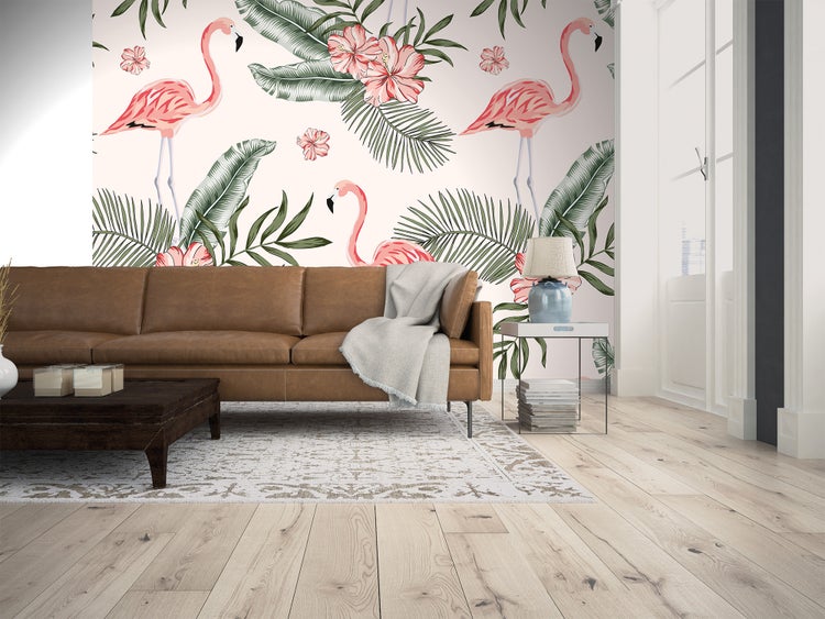 Modernes Wohnzimmer mit Tapete mit Flamingos und tropischen Blättern hinter einem braunen Ledersofa auf hellem Holzboden.