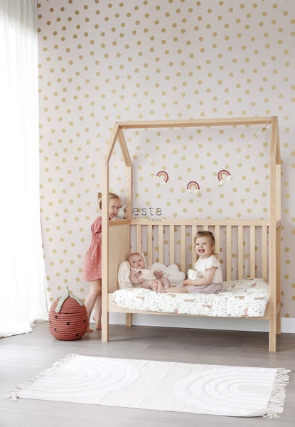 Kinderzimmer mit Kinderbett im Hausdesign, dekorativer Rainbow Girlande, Teppich und Kindern