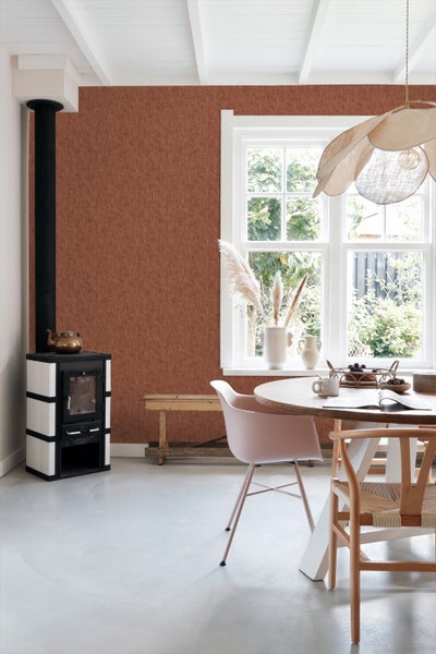 Wohnzimmer mit Sessel, Schrank, Tisch und strukturierter Tapete