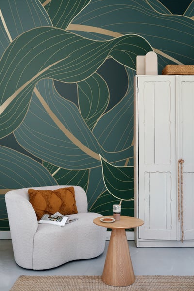 Wohnzimmer mit grün-goldener Blättertapete, Sessel und Beistelltisch