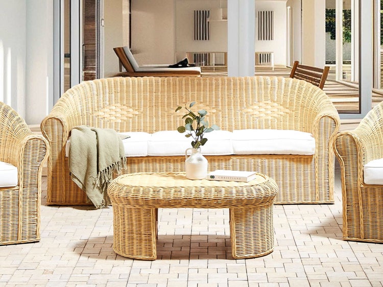 Gartenmöbelset aus Rattan mit Sofa, Sessel und Tisch auf einer Terrasse