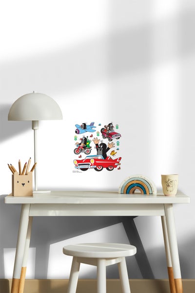 Dekoratives Kinderzimmer mit einem Wandaufkleber, der den kleinen Maulwurf in verschiedenen Fahrzeugen zeigt.