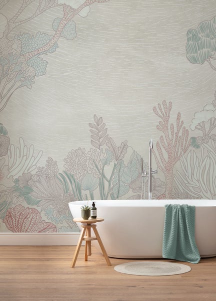 Badezimmer mit Badewanne vor Wandtapete mit Pflanzenmuster