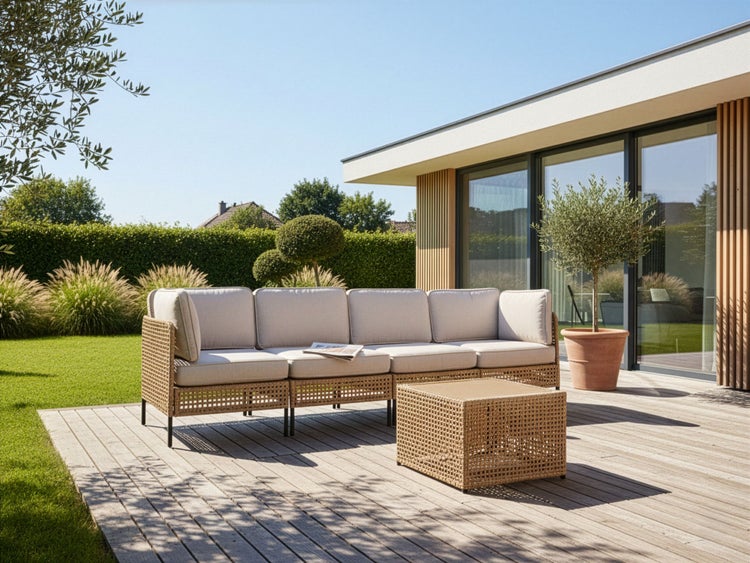 Gartenszene mit Rattan-Lounge-Set auf einer Holzterrasse an einem sonnigen Tag