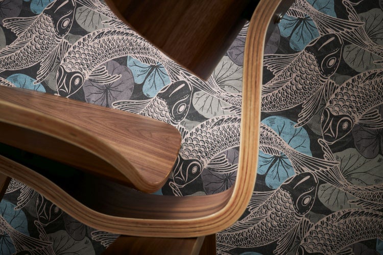 Verschiedene Tapetenrollen mit Fischmotiven in einem geflochtenen Korb