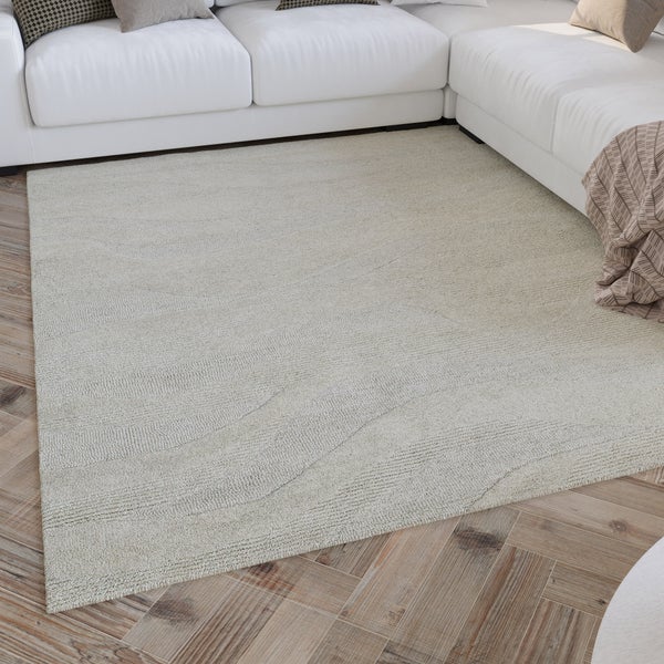 Strukturierter Teppich in hellem Wohnzimmer vor weißem Sofa auf Holzfußboden.