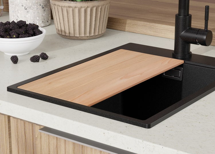 Küchenspüle mit Schneidebrett und Armatur auf einer Küchentheke