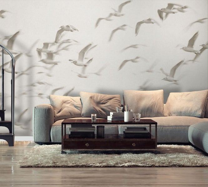 Wohnzimmer mit Tapete mit Möwenmuster, Sofa, Couchtisch und Teppich