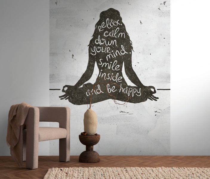 Fototapete mit meditierender Silhouette und Text relax calm down your mind smile inside and be happy in einem Zimmer mit Sessel und Teppich.