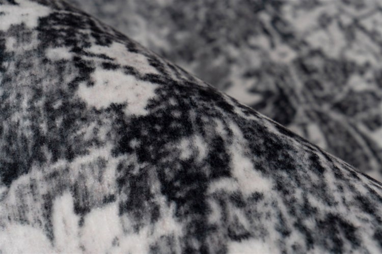 Nahaufnahme der Textur eines Teppichs mit weichem Flor und abstraktem Muster.