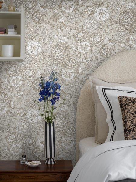 Wohnzimmer mit floral gemusterter Tapete, Sofa und Dekorationen