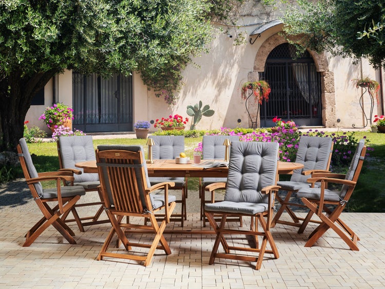 Gartengarnitur mit ovalem Tisch und sechs Klappstühlen mit Sitzkissen