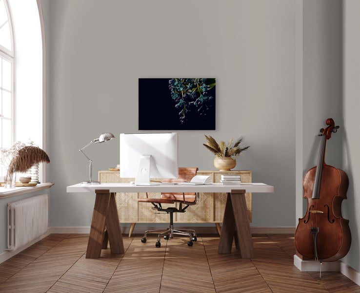 Modernes Arbeitszimmer mit Schreibtisch aus Holz, Bürostuhl, Computer, Lampe und Kontrabass vor einer Wand mit Leinwandbild und Fischgrätparkett.