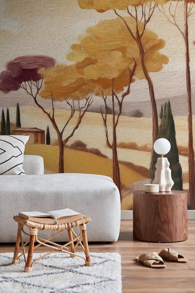 Wohnzimmer mit Wandbild toskanischer Landschaft, Sofa, Beistelltisch, Lampe, Hocker und Teppich