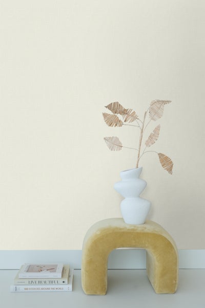 Helle, textile Vliestapete im Interieur mit Vase und Dekoration auf einem Hocker