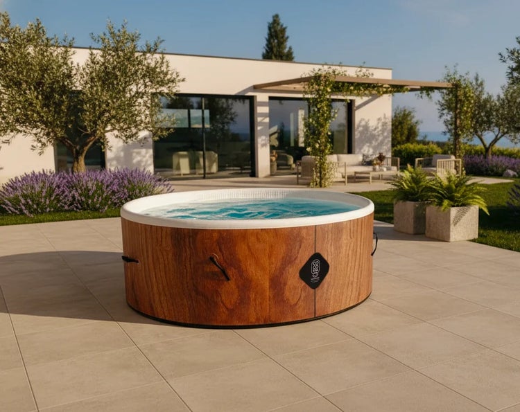 Aufblasbarer runder Whirlpool in Holzoptik auf einer gefliesten Terrasse im sonnigen Garten mit Haus im Hintergrund.