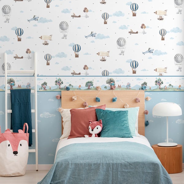 Kinderzimmer mit Bett, Leiter und Aufbewahrungskorb vor einer Tapete mit Flugzeug- und Ballonmotiven.