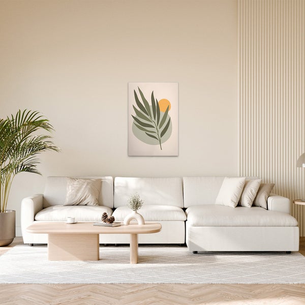 Wohnzimmer mit einem Sofa, einem Tisch und einem gerahmten Bild mit Pflanzenmotiv an der Wand