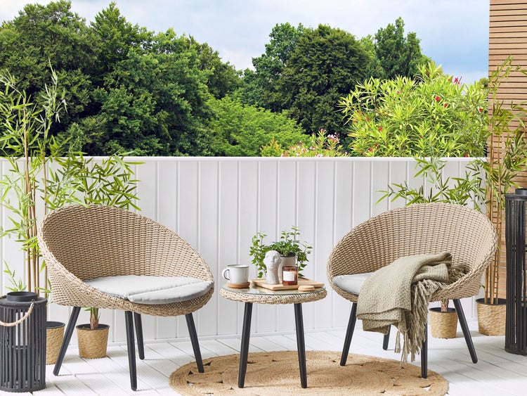 Balkon mit Korbsesseln, Beistelltisch und dekorativen Elementen für eine gemütliche Atmosphäre im Freien.