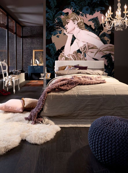 Schlafzimmer mit Bett, Wandbild und dekorativen Elementen für eine gemütliche Atmosphäre.