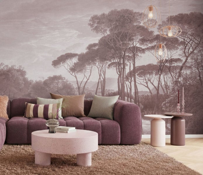 Moderne Wohnzimmer-Einrichtung mit Fototapete eines nebligen Pinienwaldes, Polstersofa, runden Couchtischen und Hängeleuchten.