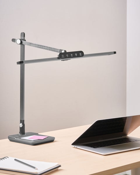 Schreibtisch mit LED-Lampe, Notizblock, Bleistift und Laptop