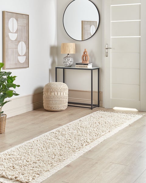 Hellbeige Zottel-Läufer auf hellem Holzboden in einem modern eingerichteten Flur mit Konsolentisch, Spiegel und Pouf.