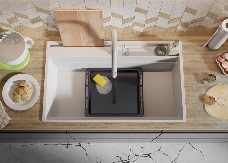 Küchenspüle mit Backblech, Spülmittel und Spülschwamm in einer hellen Küche