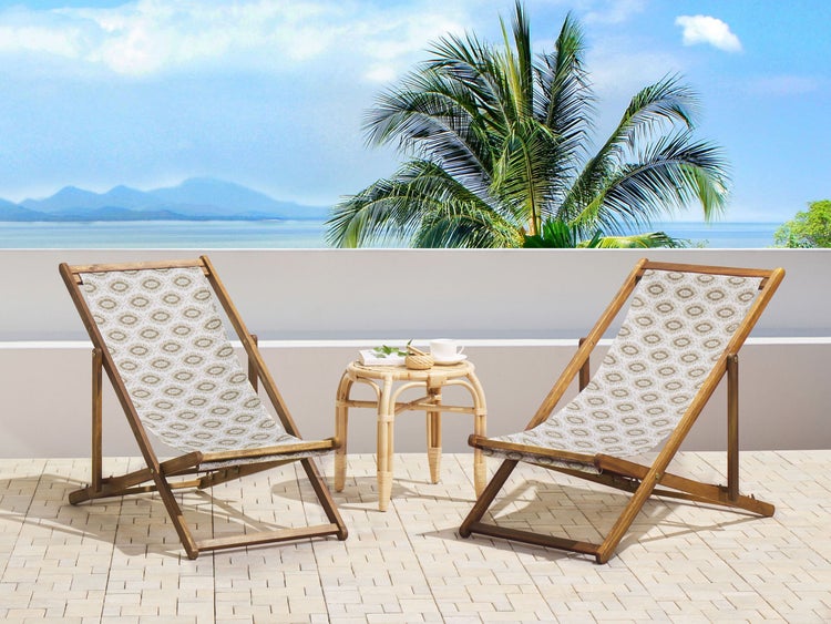 Szene mit zwei Liegestühlen und einem Beistelltisch auf einer Terrasse mit Meerblick