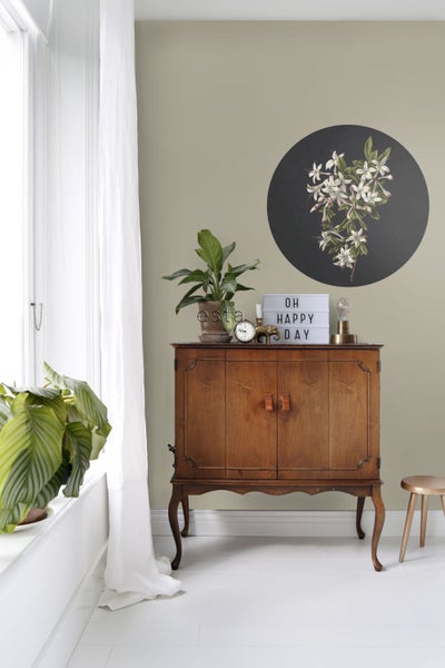 Wohnzimmer mit Holzschrank, Zimmerpflanzen und Wanddekoration