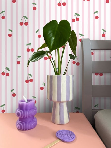 Dekorative Szene mit Pflanze im Topf, Kerze und Kunsthandwerk auf einem Tisch