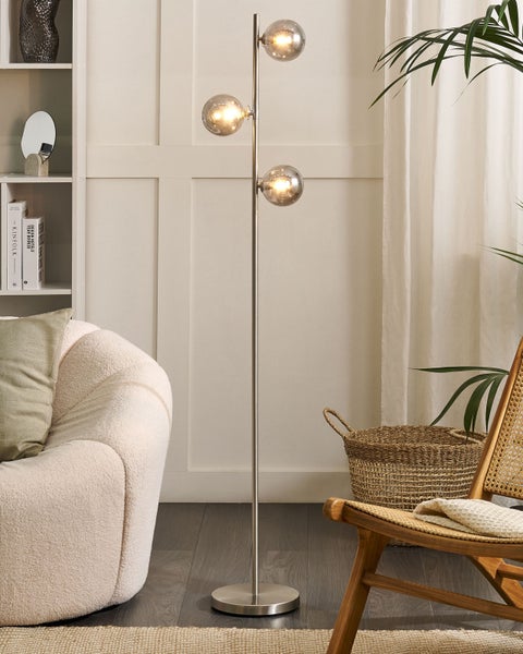 Stehlampe mit drei Leuchten in einer dekorierten Wohnumgebung