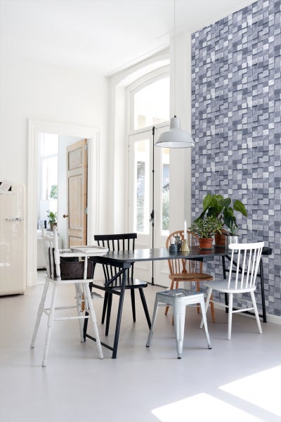 Esszimmer mit Esstisch, Stühlen, Pendelleuchte und Wandverkleidung in Steinoptik