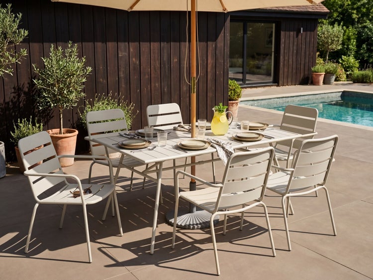 Gartenmöbel-Set aus Metall mit rechteckigem Tisch und sechs Stühlen auf einer Terrasse am Pool unter einem Sonnenschirm.