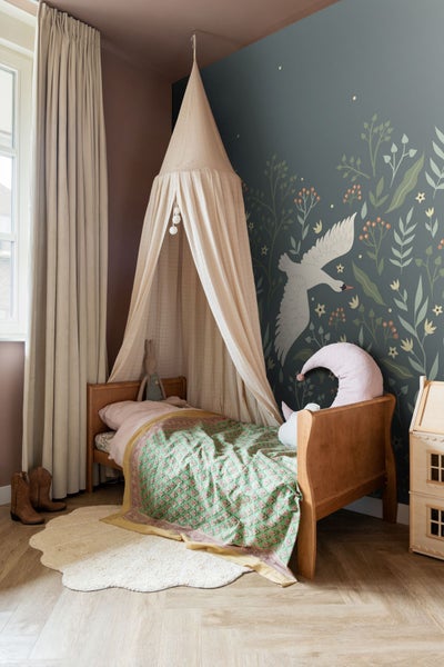 Kinderzimmer mit Himmelbett, Wandtapete mit Vogelmotiv, Bett und Teppich