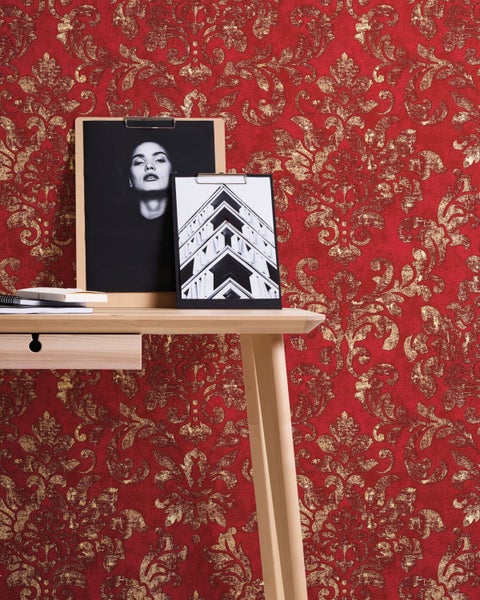 Dekorative Szene mit einem Kissen mit Hirschmotiv auf einer Holzbank neben einem Holzstapel und einer Kerze